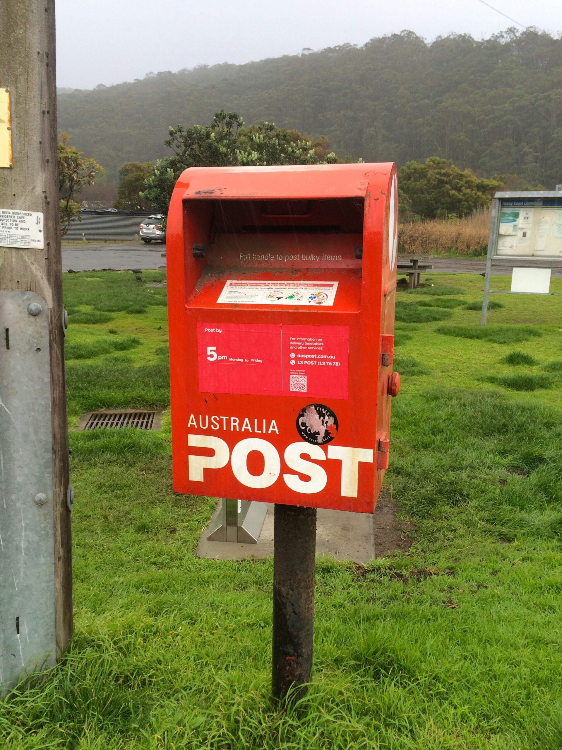 australia-post-mailbox-rural-location Australia Post red street mailbox in a grassy rural setting with hills in the background