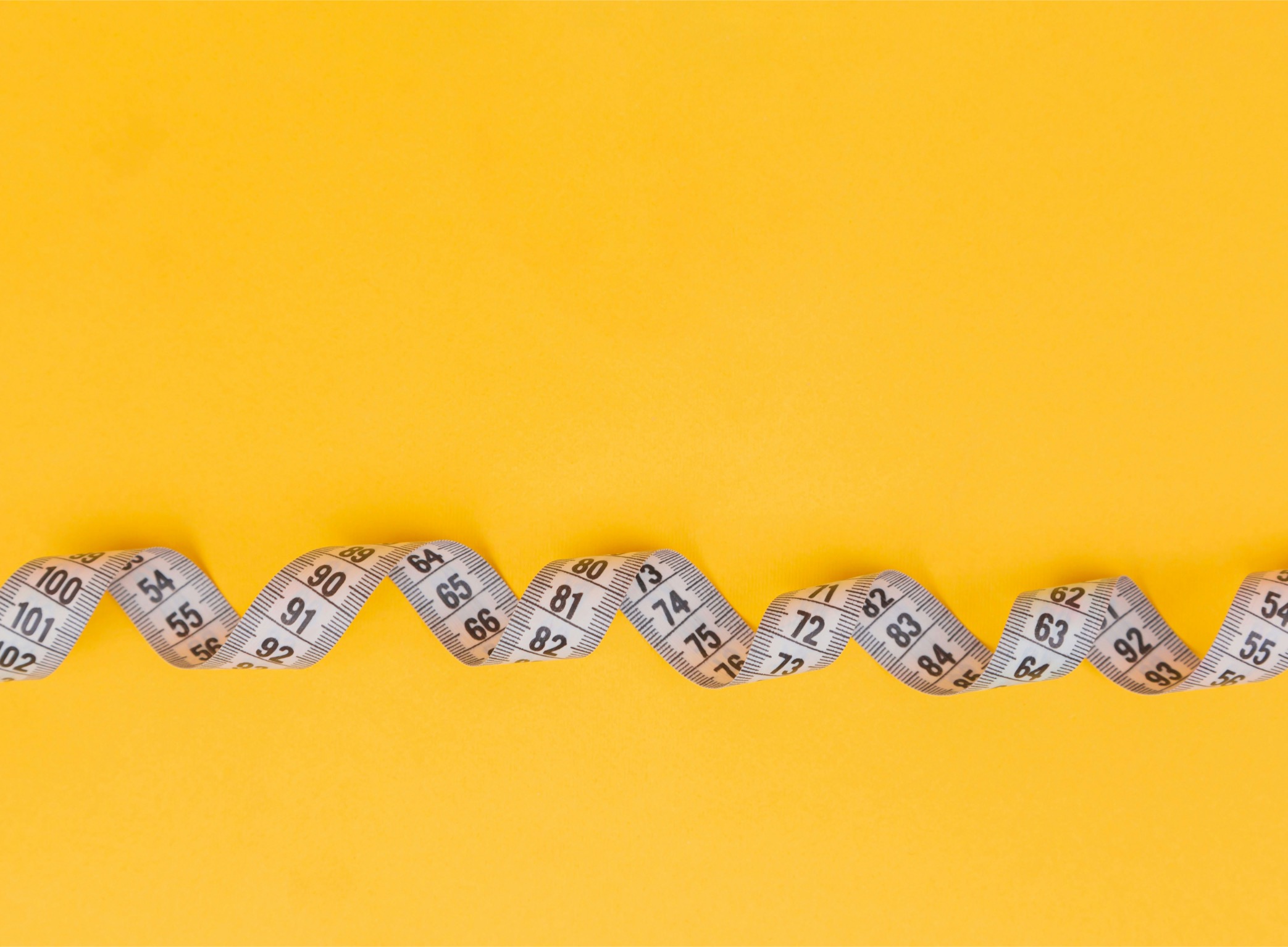 cause-marketing-measurement-tape-yellow Measuring tape on yellow background representing how to measure cause marketing success and track event metrics