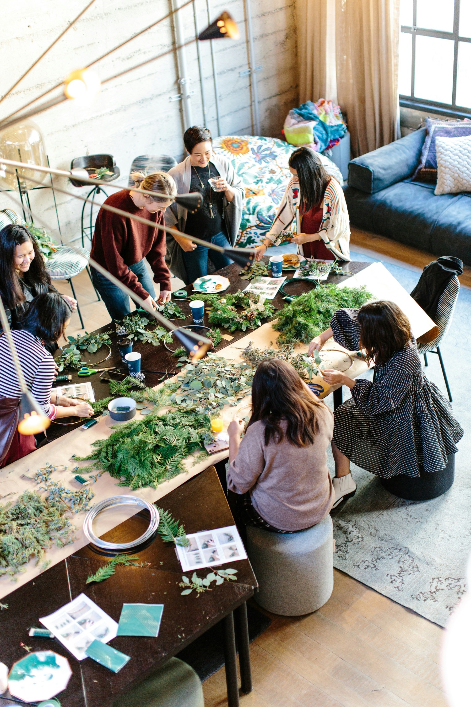 cause-marketing-wreath-making-workshop-event Group of women making holiday wreaths together at a cause marketing workshop event, creating hands-on engagement for environmental charity